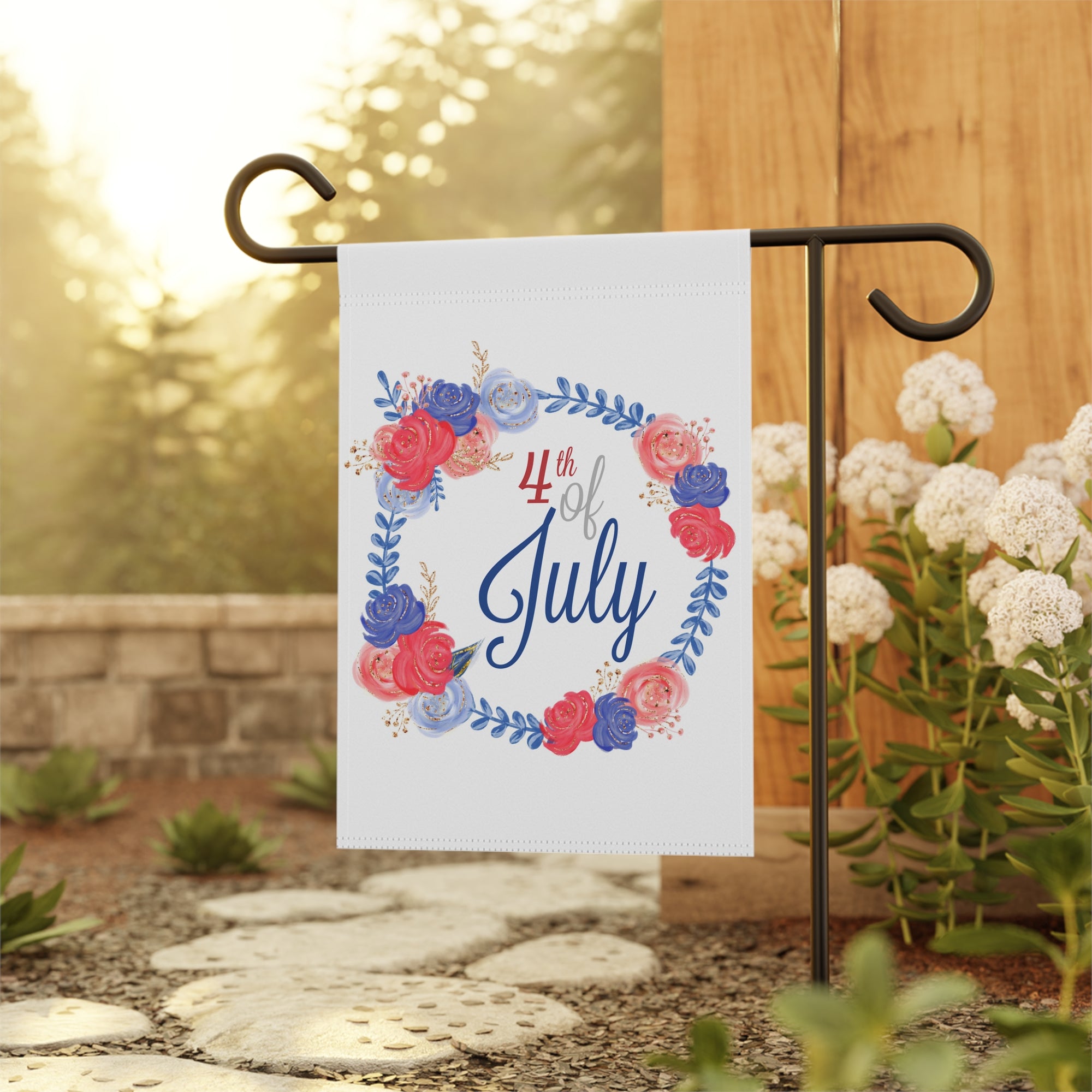 Patriotic floral wreath garden flag displayed outdoors on a flag stand