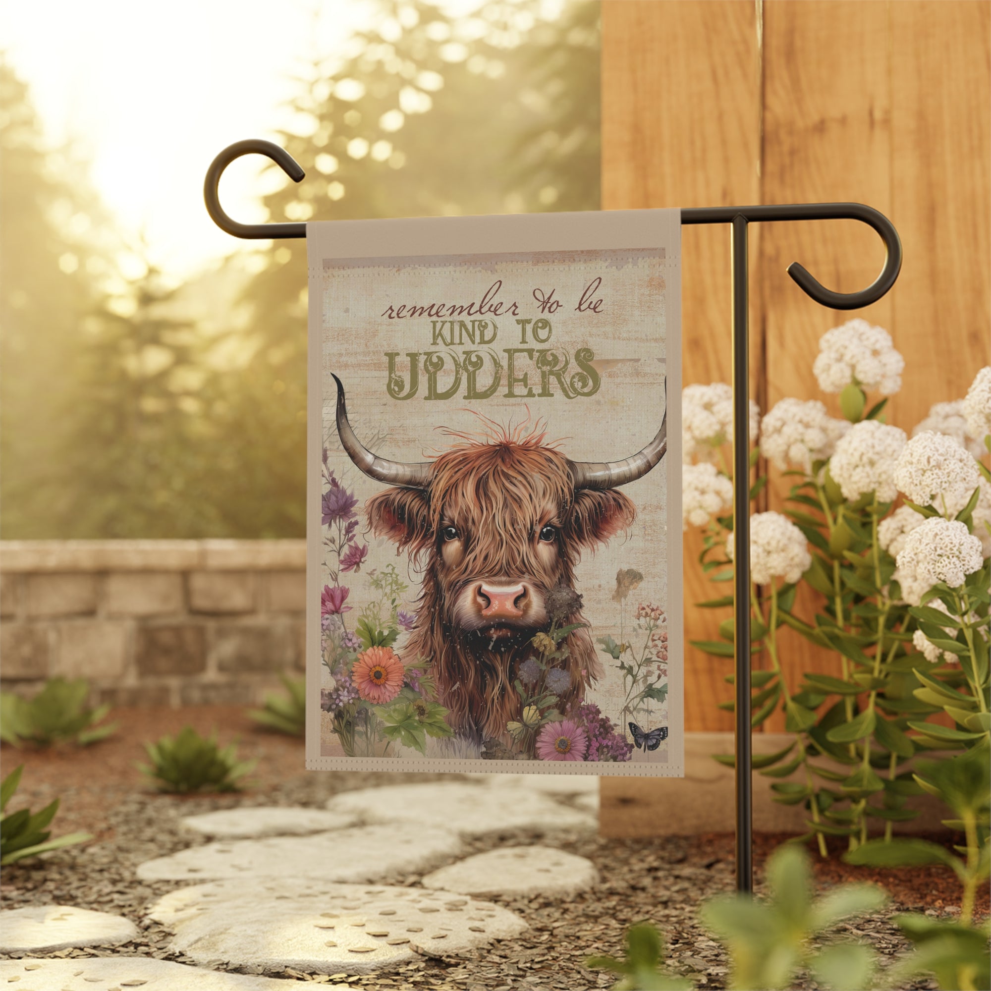 Punny highland cow kindness garden flag displayed outdoors on a flag stand