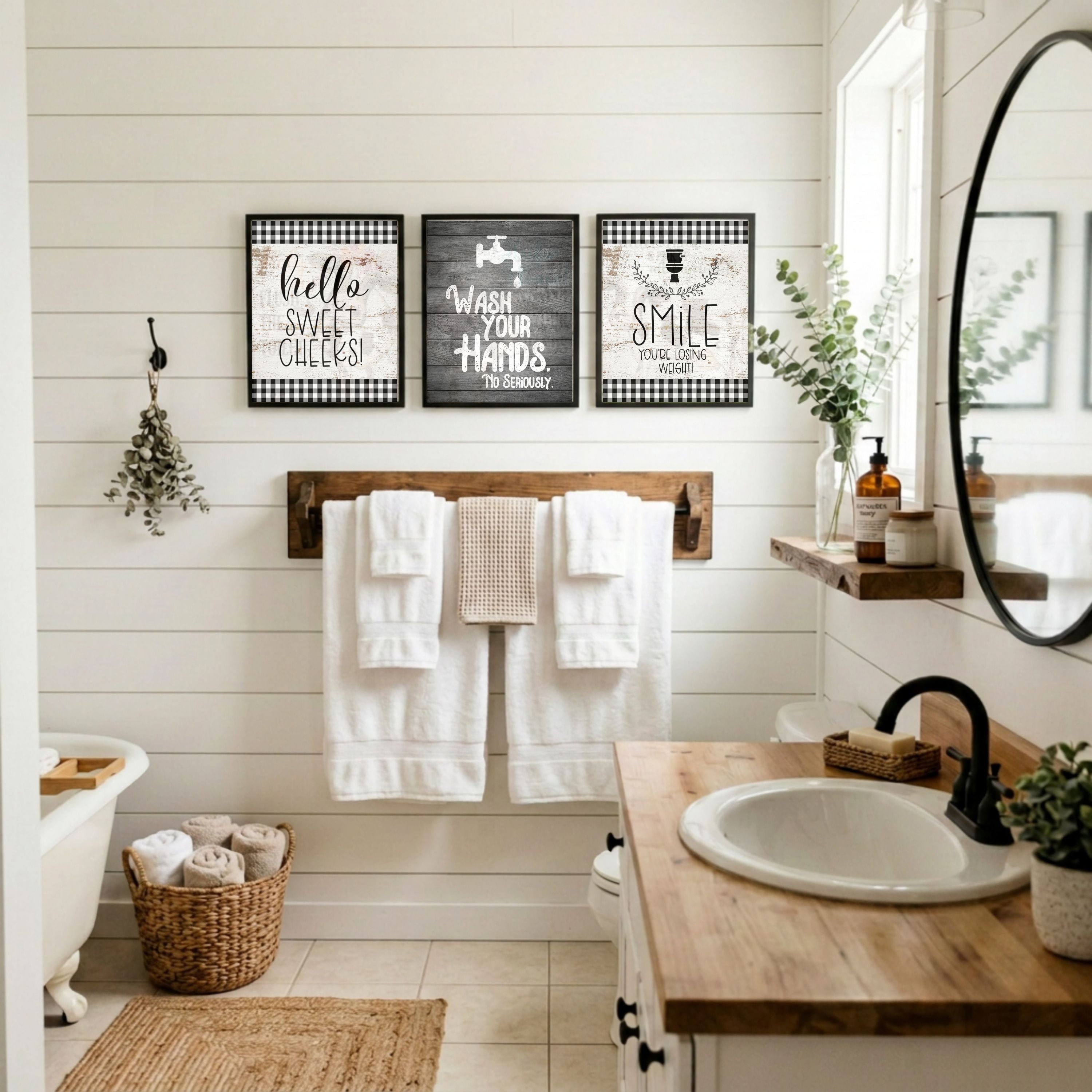 Bathroom with wooden vanity, towel rack, and decorative signs on a white wall.