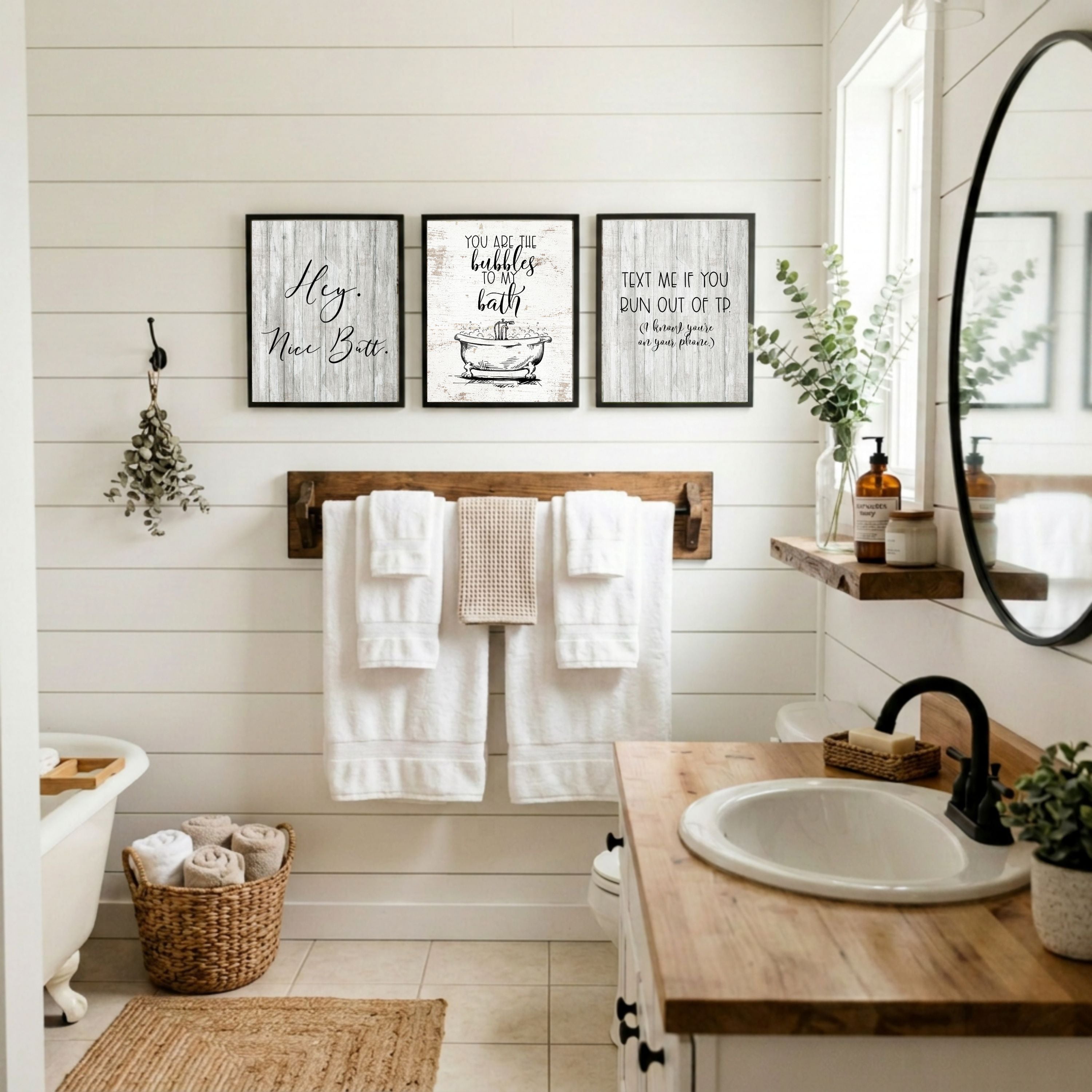 Bathroom with wooden vanity, towel rack, and framed prints on a white wall.