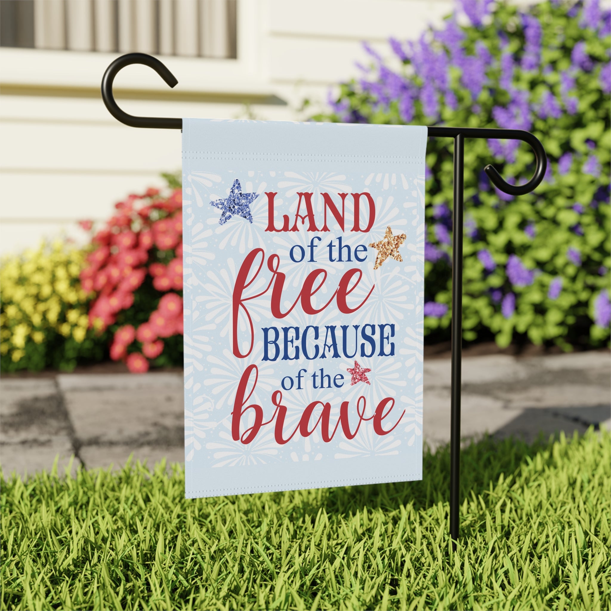 Close-up of Land of the Free Because of the Brave garden flag with stars and stripes