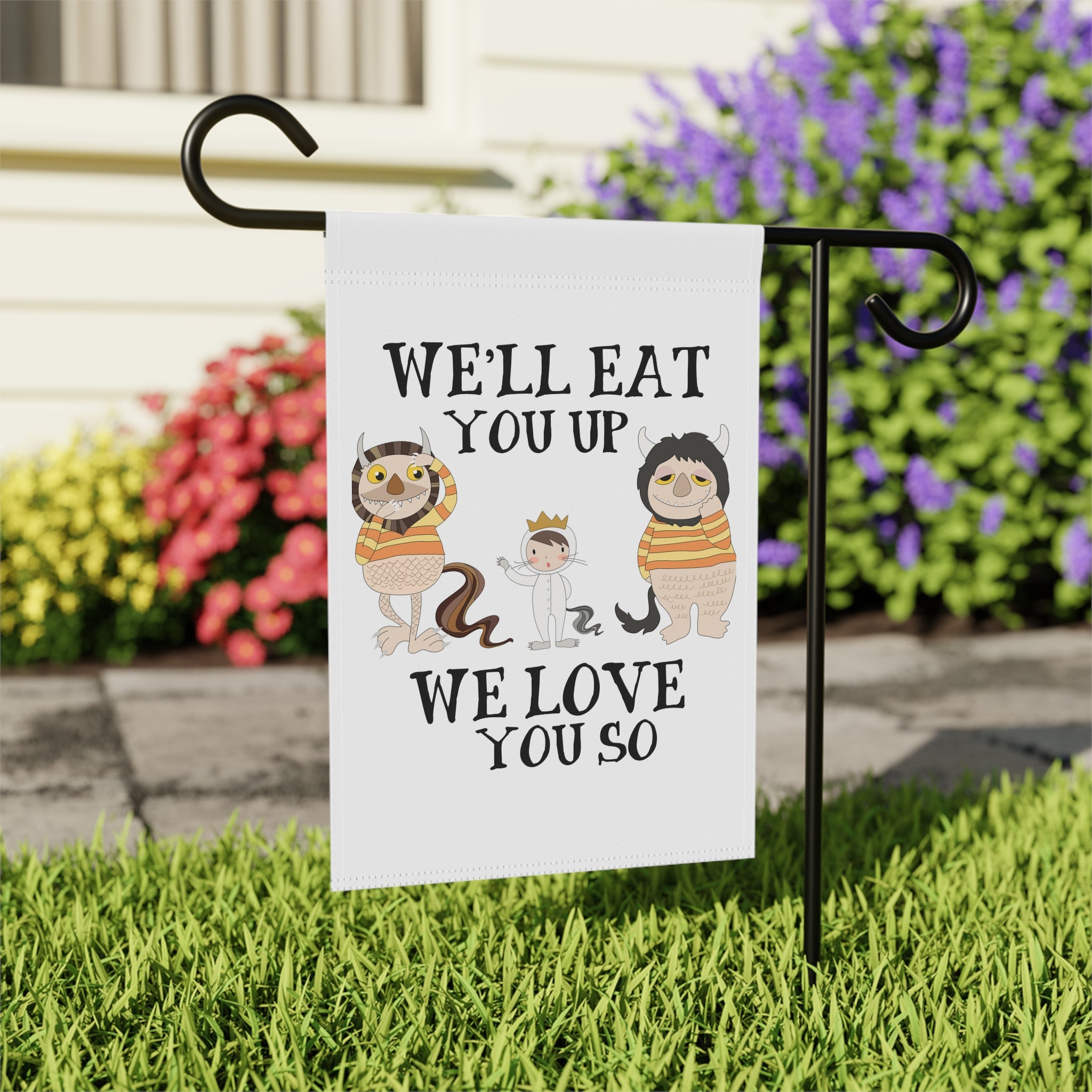 Close-up of We Love You So Monster garden flag with hand-drawn storybook design