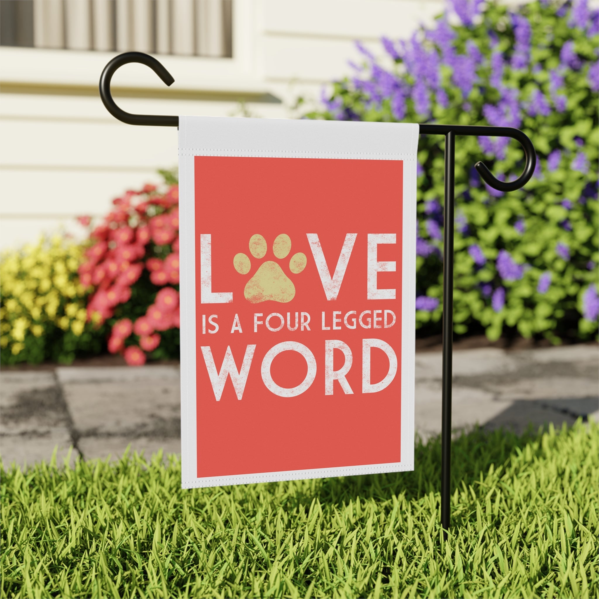 Close-up of Love Is A Four Legged Word garden flag with paw print detail