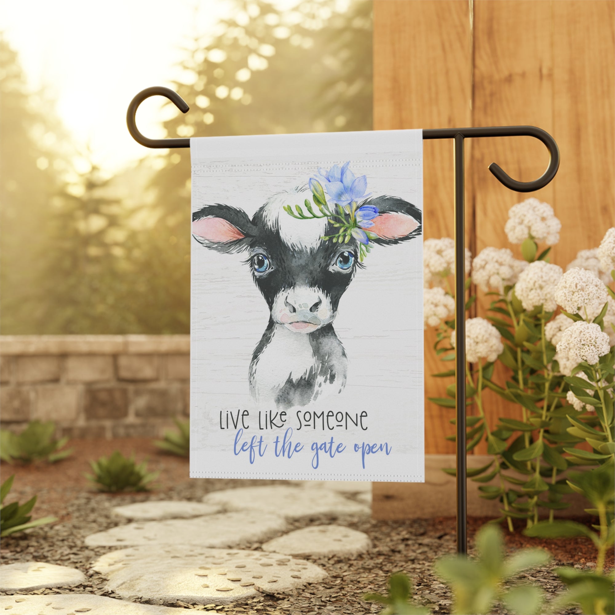 Country cow farmhouse garden flag displayed outdoors on a flag stand