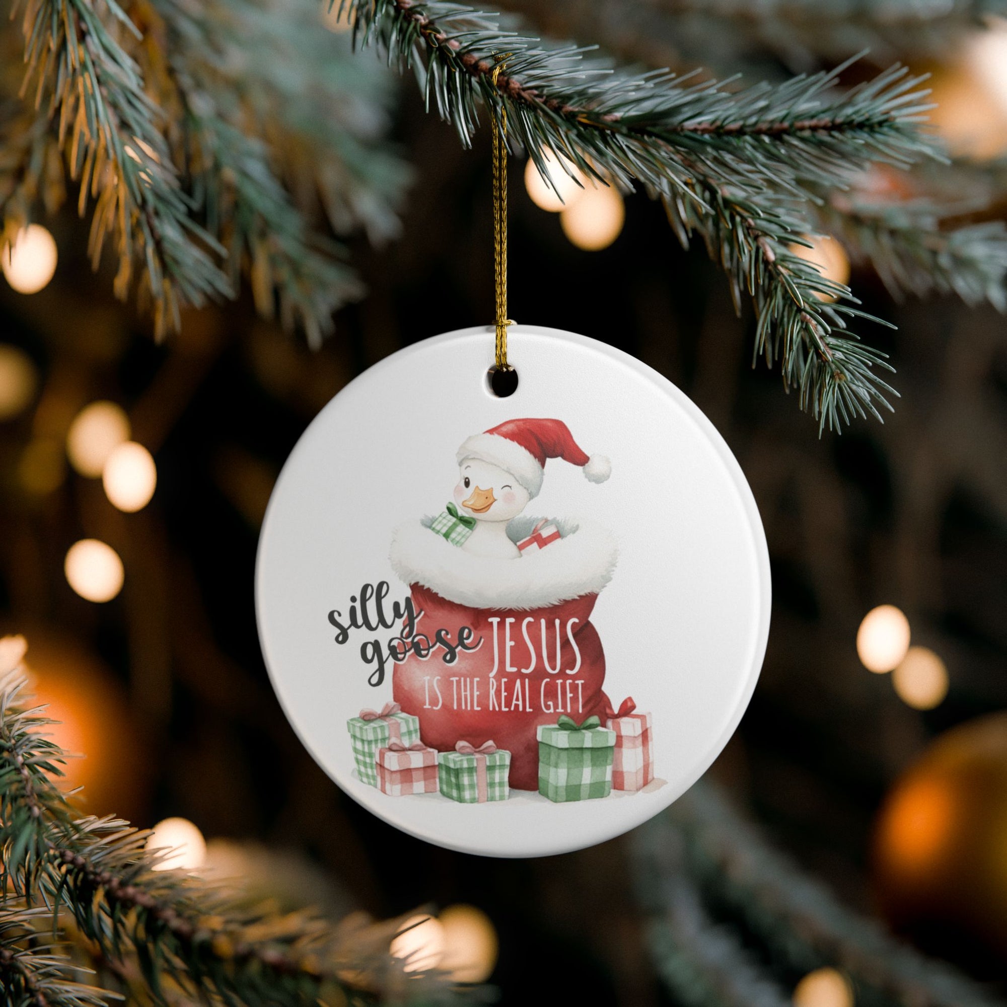 Christmas ornament with a silly goose design and text hanging on a tree.