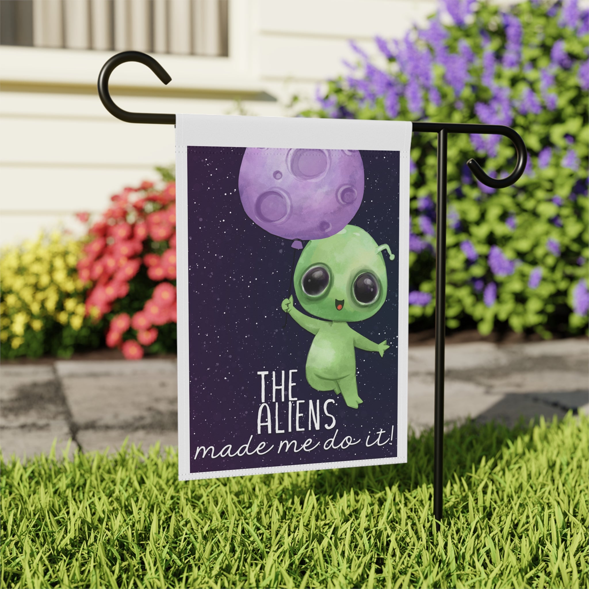 Close-up of The Aliens Made Me Do It garden flag with whimsical alien design
