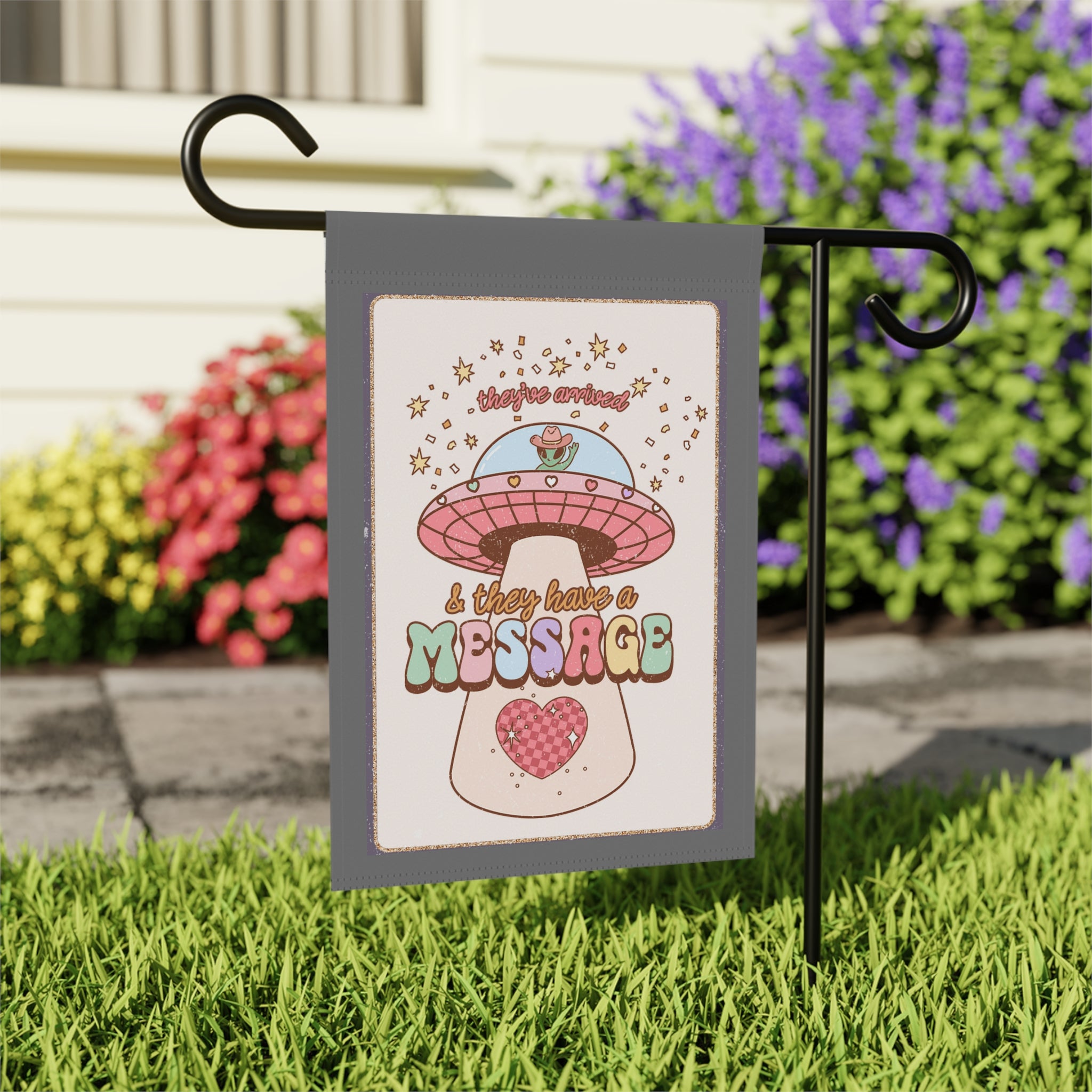 Close-up of They Have A Message garden flag with western alien design