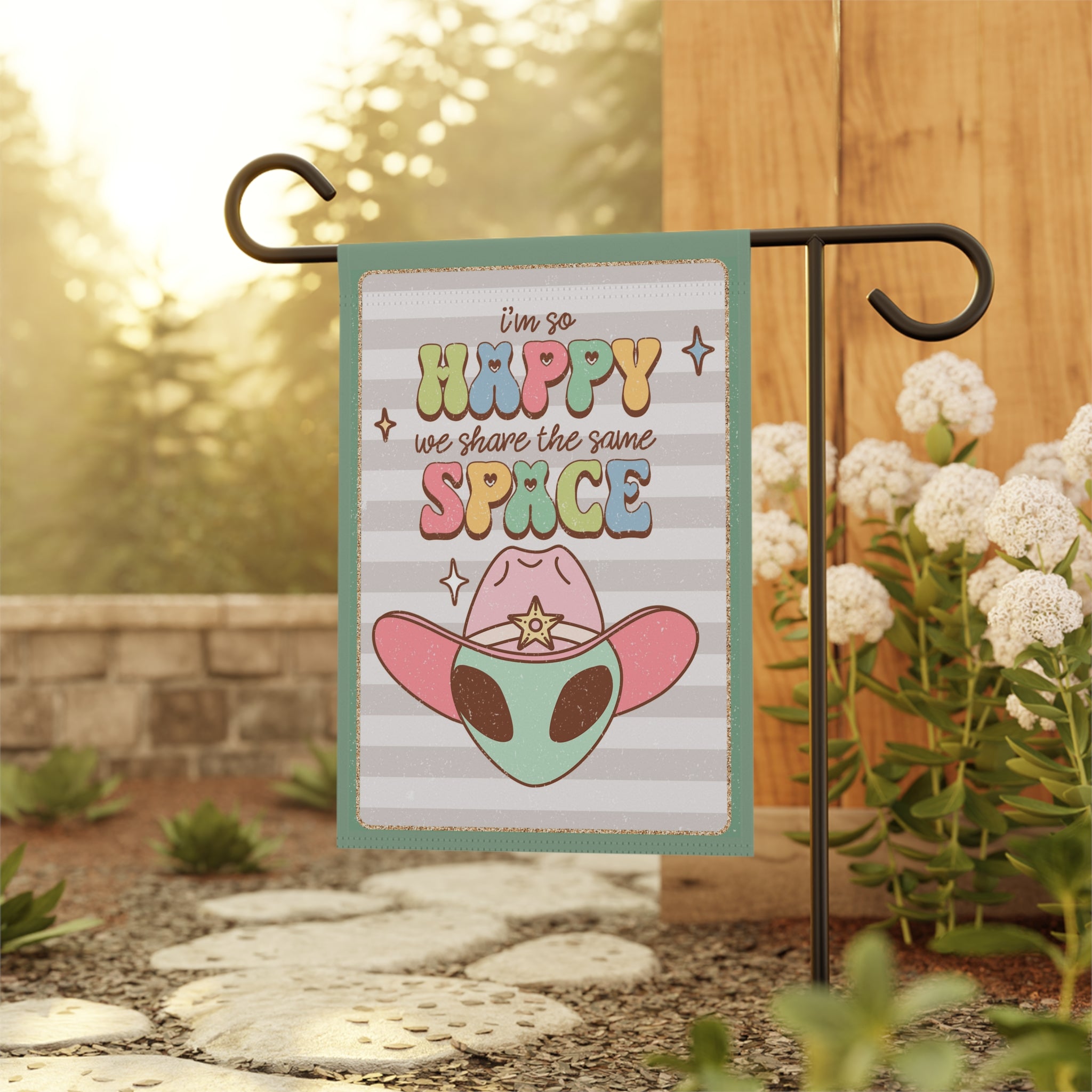 Inclusive cowboy alien peace garden flag displayed outdoors on a porch