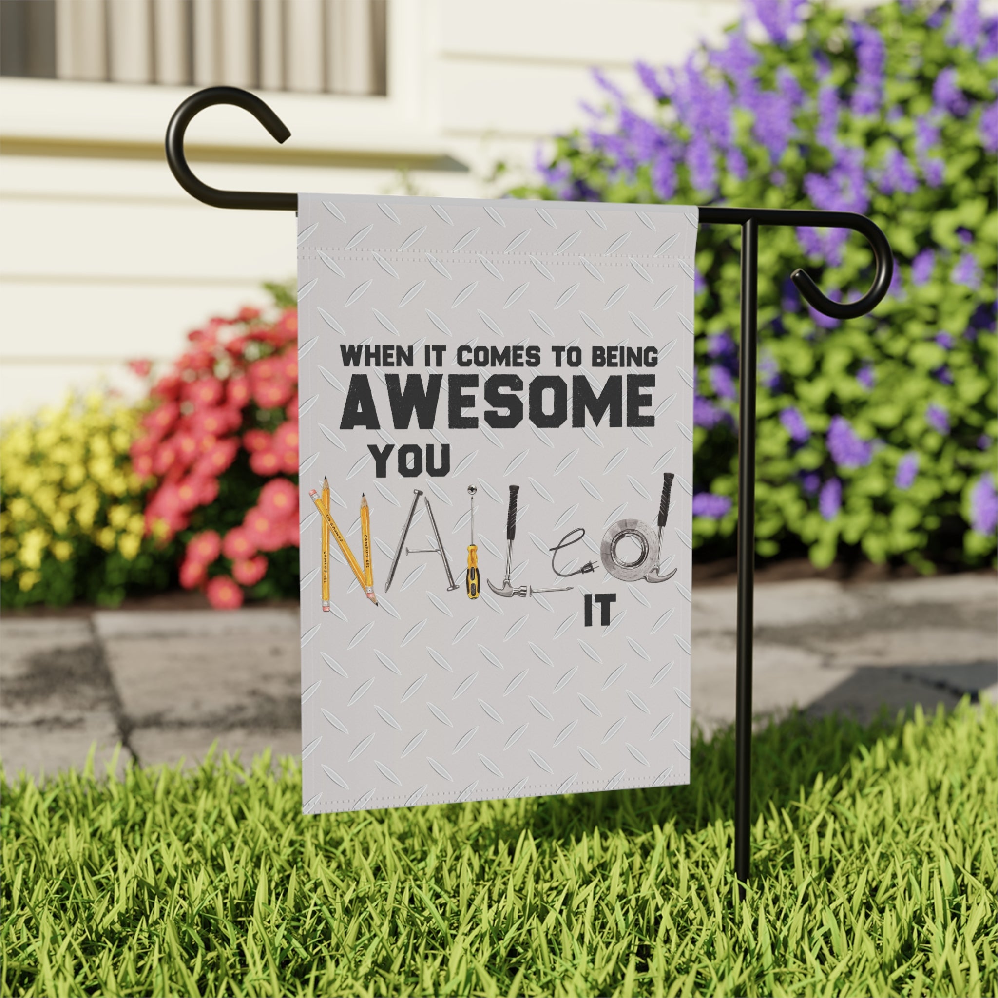 Close-up of You Nailed It garden flag with hand-illustrated tool detail