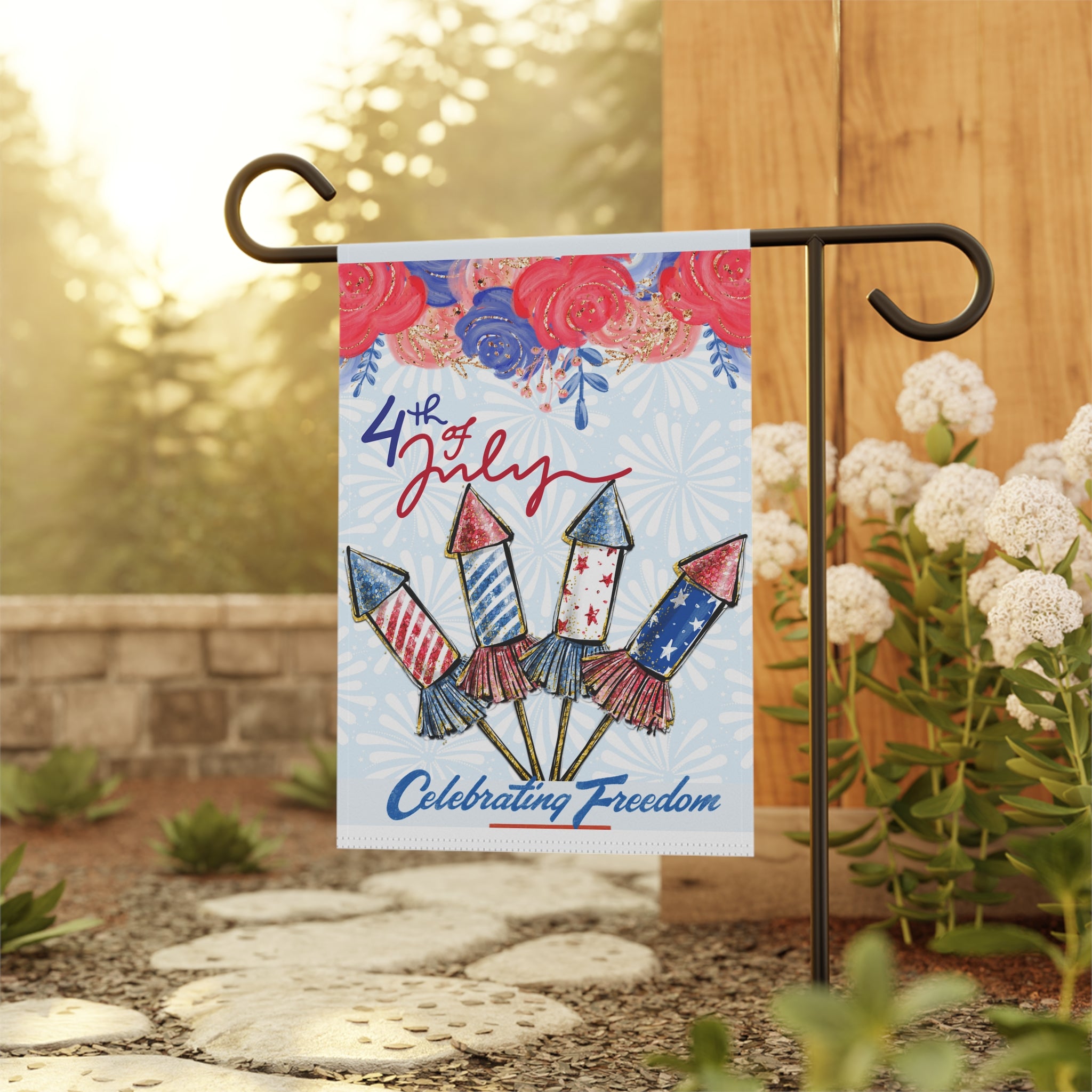 Patriotic Fireworks & Florals garden flag displayed outdoors on a flag stand