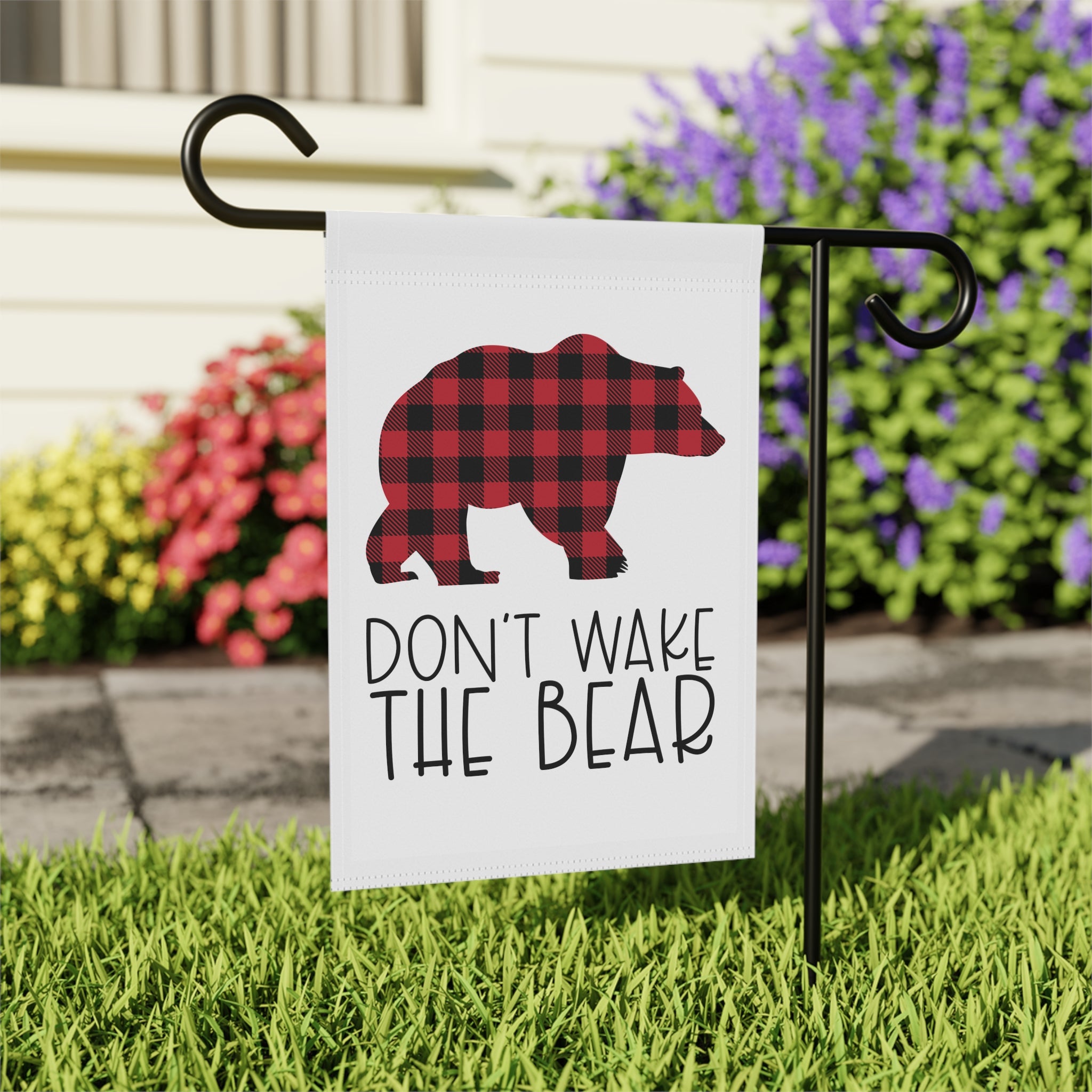 Close-up of Don't Wake The Bear garden flag with red plaid pattern detail