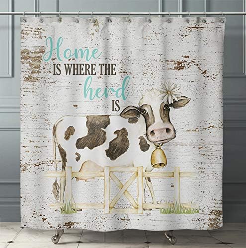 A shower curtain with a watercolor design featuring a cow in a field, with the text 'Home is where the herd is'.