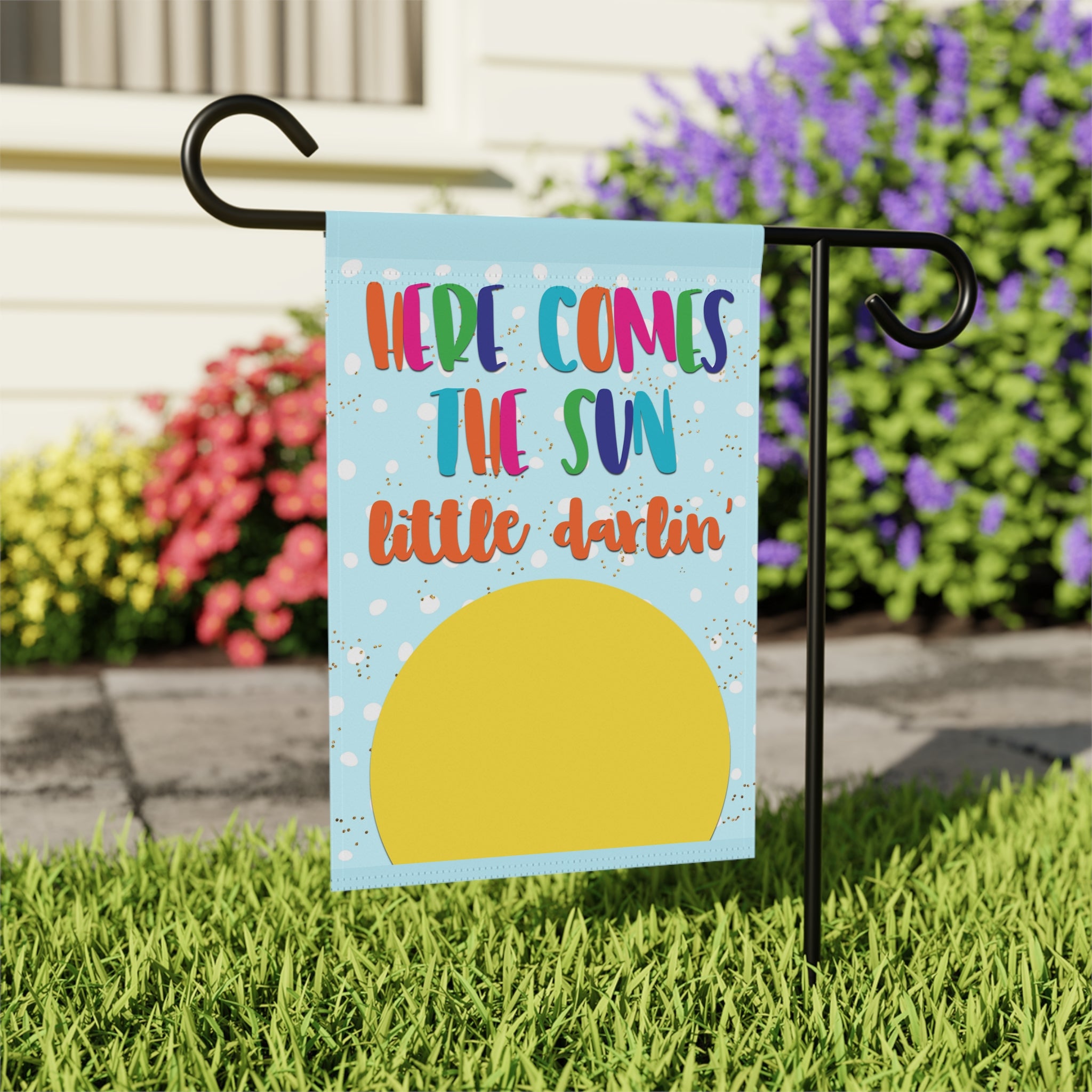 Close-up of Here Comes the Sun garden flag with happy sunny typography detail