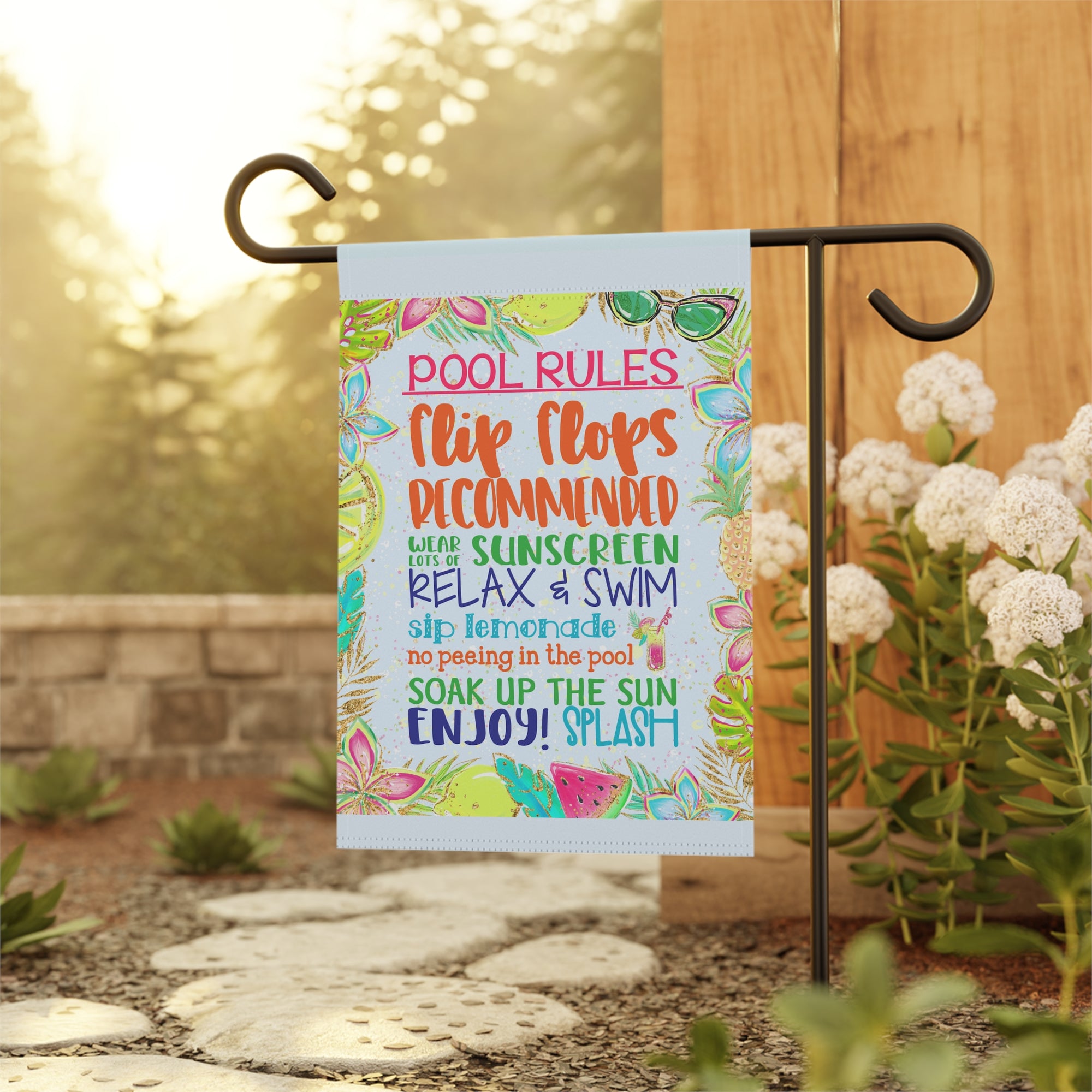 Funny pool rules garden flag displayed outdoors at a backyard pool