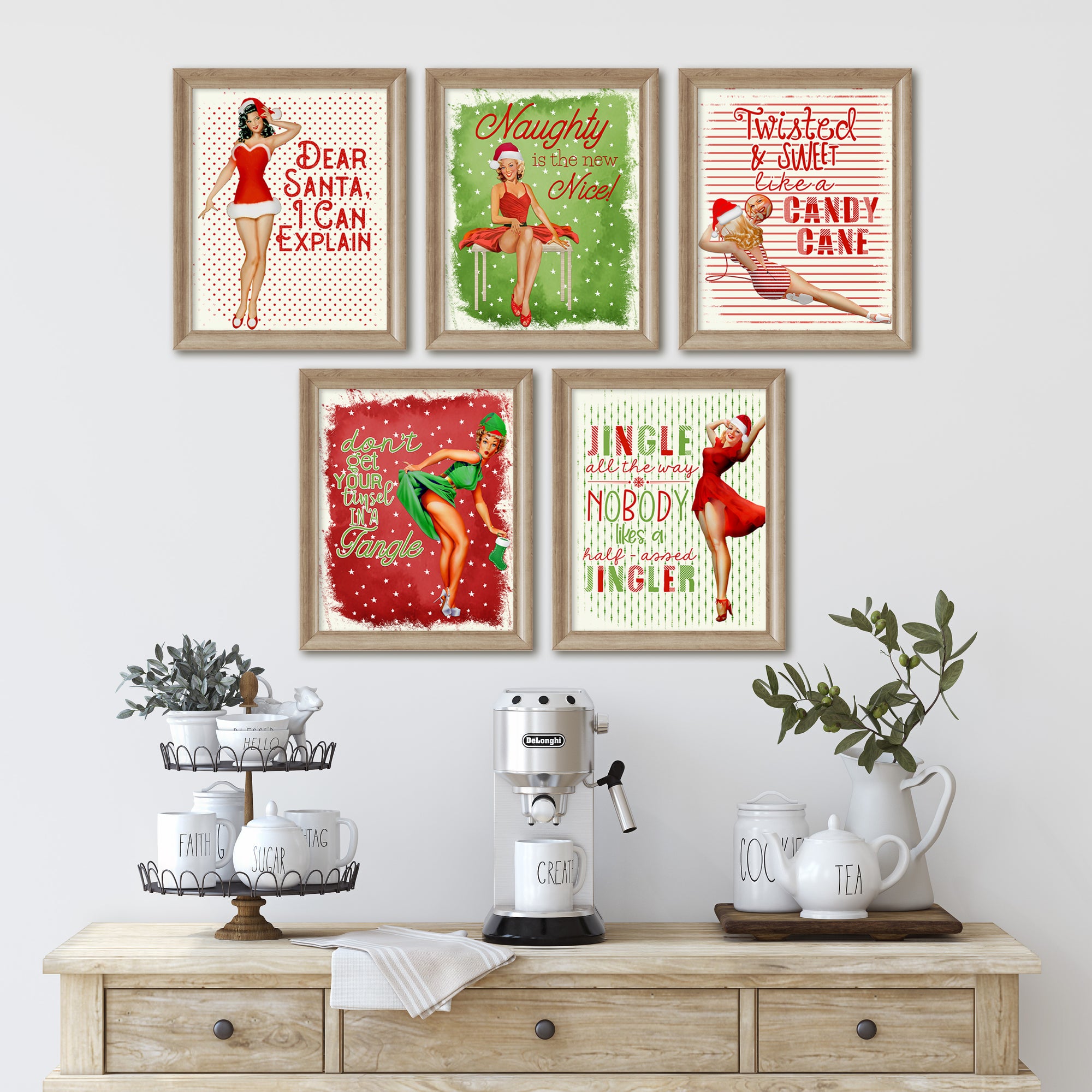 Set of framed Christmas-themed prints on a wall above a wooden console table with decorative items.