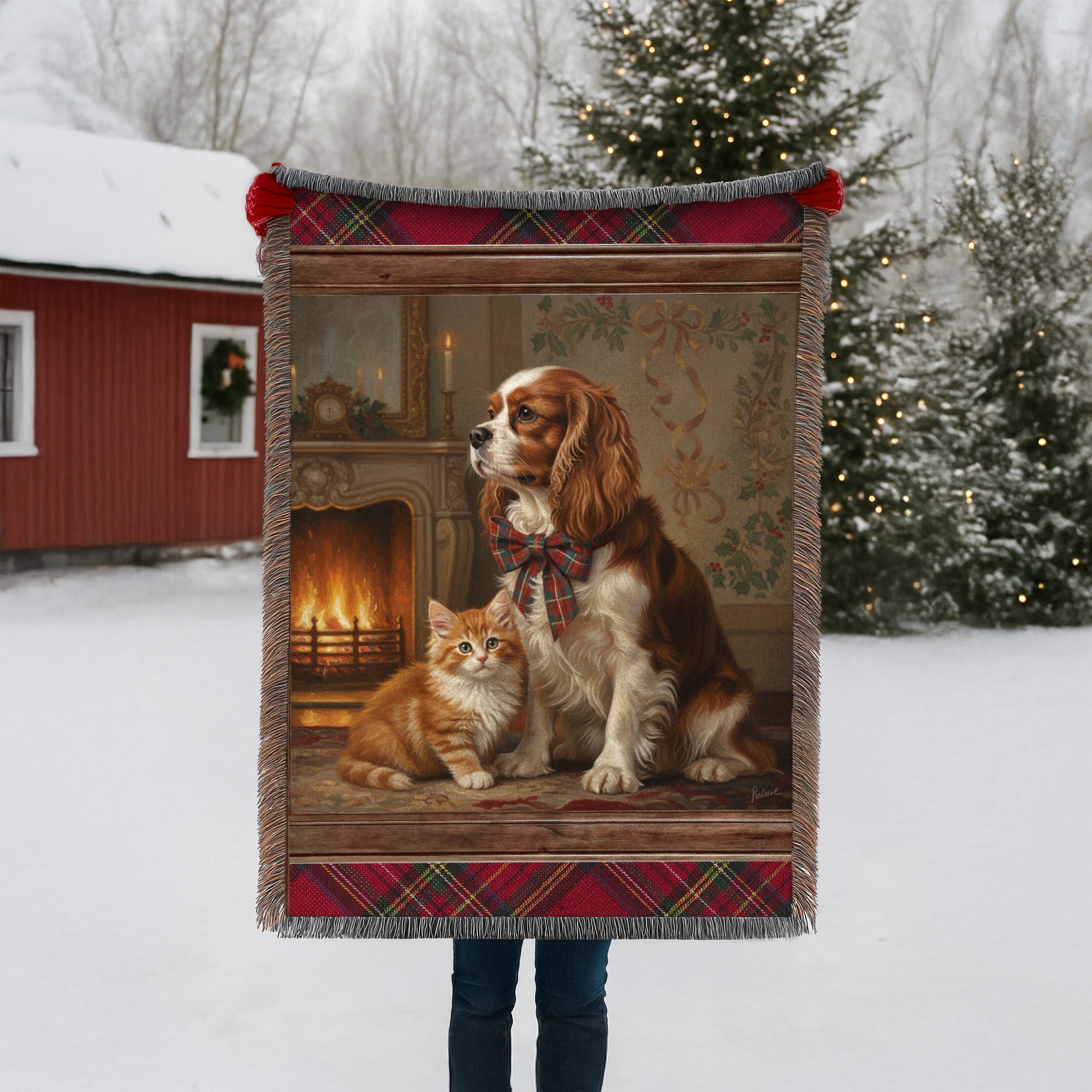Blanket with a dog and cat design held by a person in a snowy landscape.