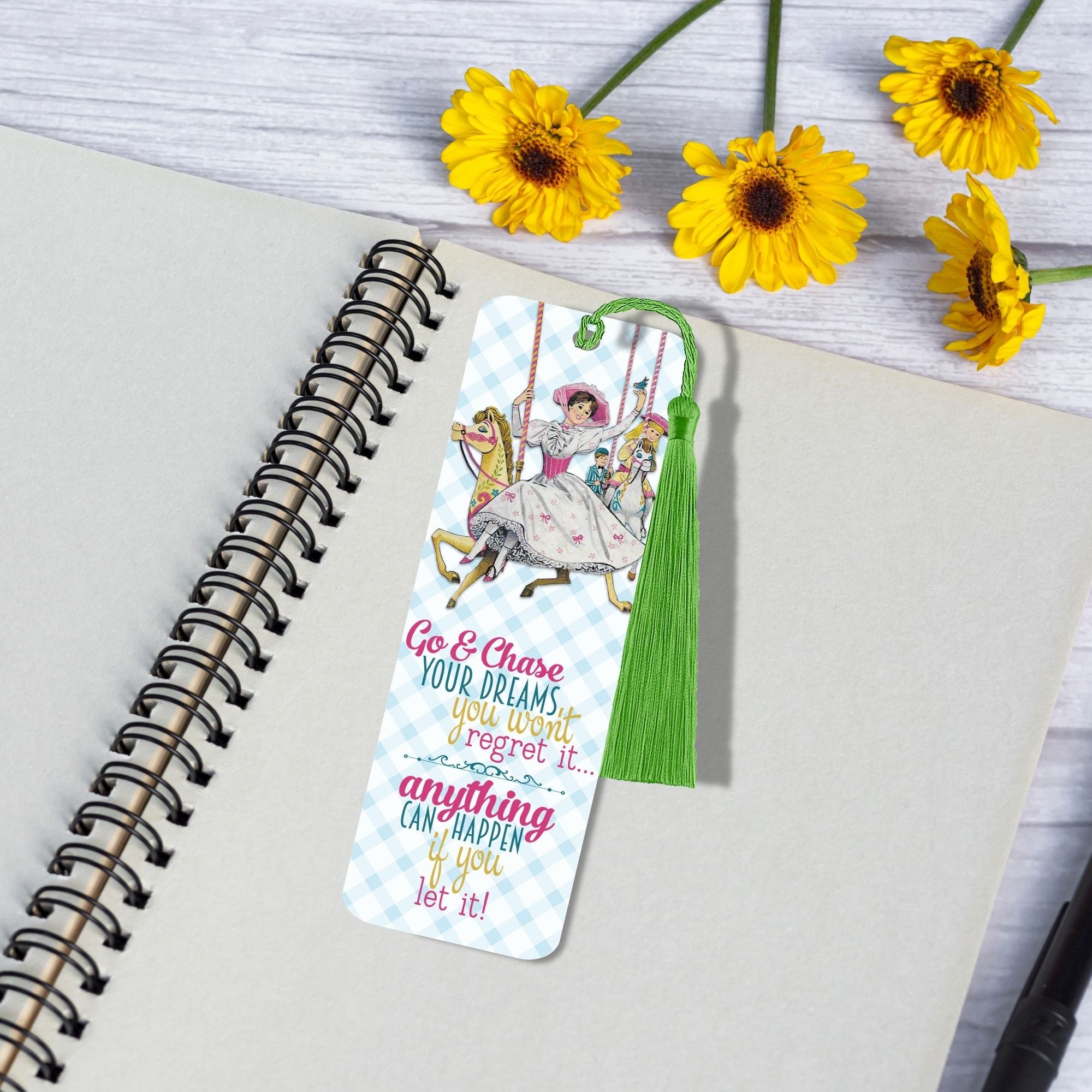 Colorful bookmark with motivational quote on a notebook with yellow flowers