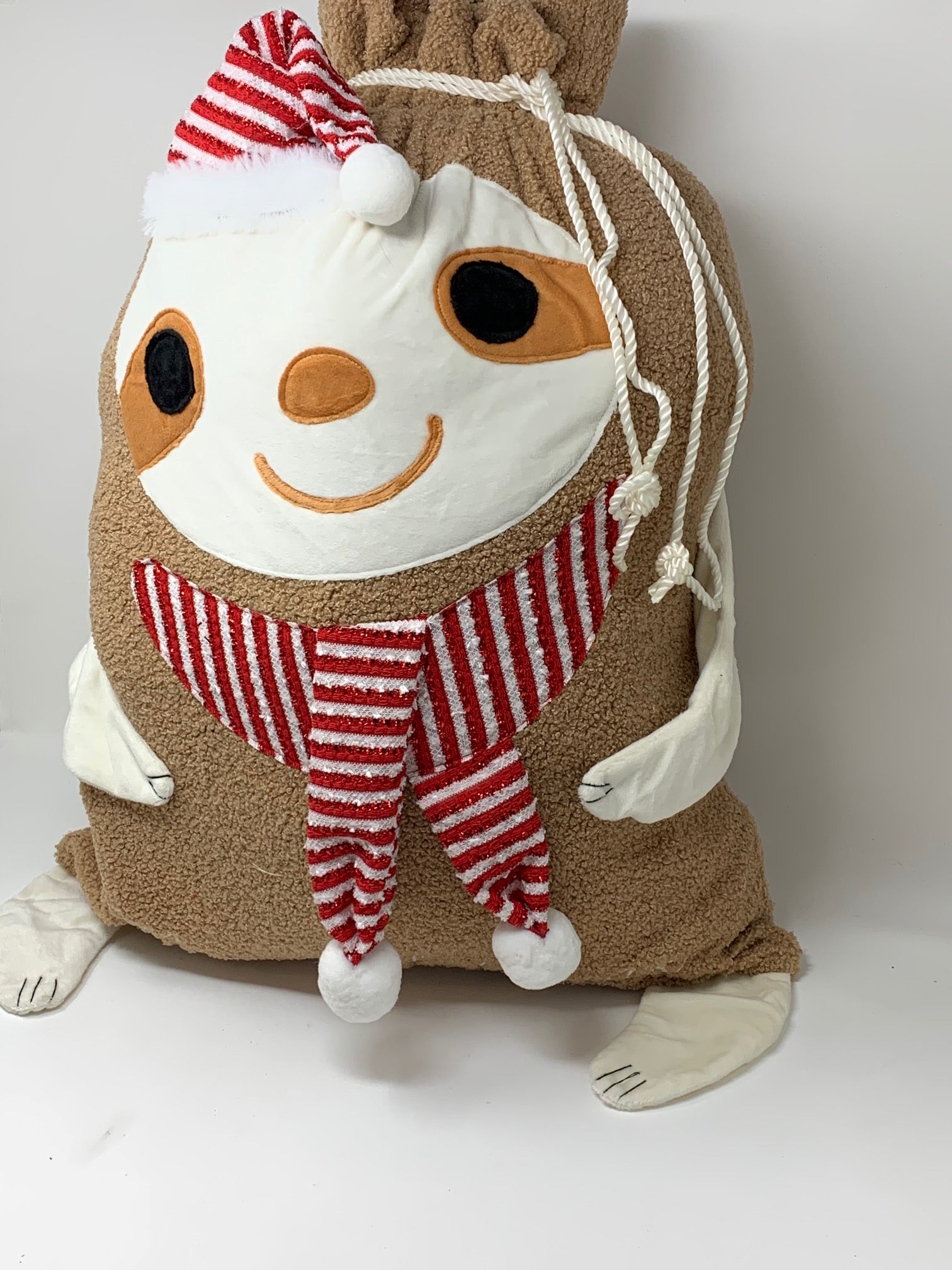 Side view of the sloth Christmas gift bag showing the drawstring closure cinched at the top.
