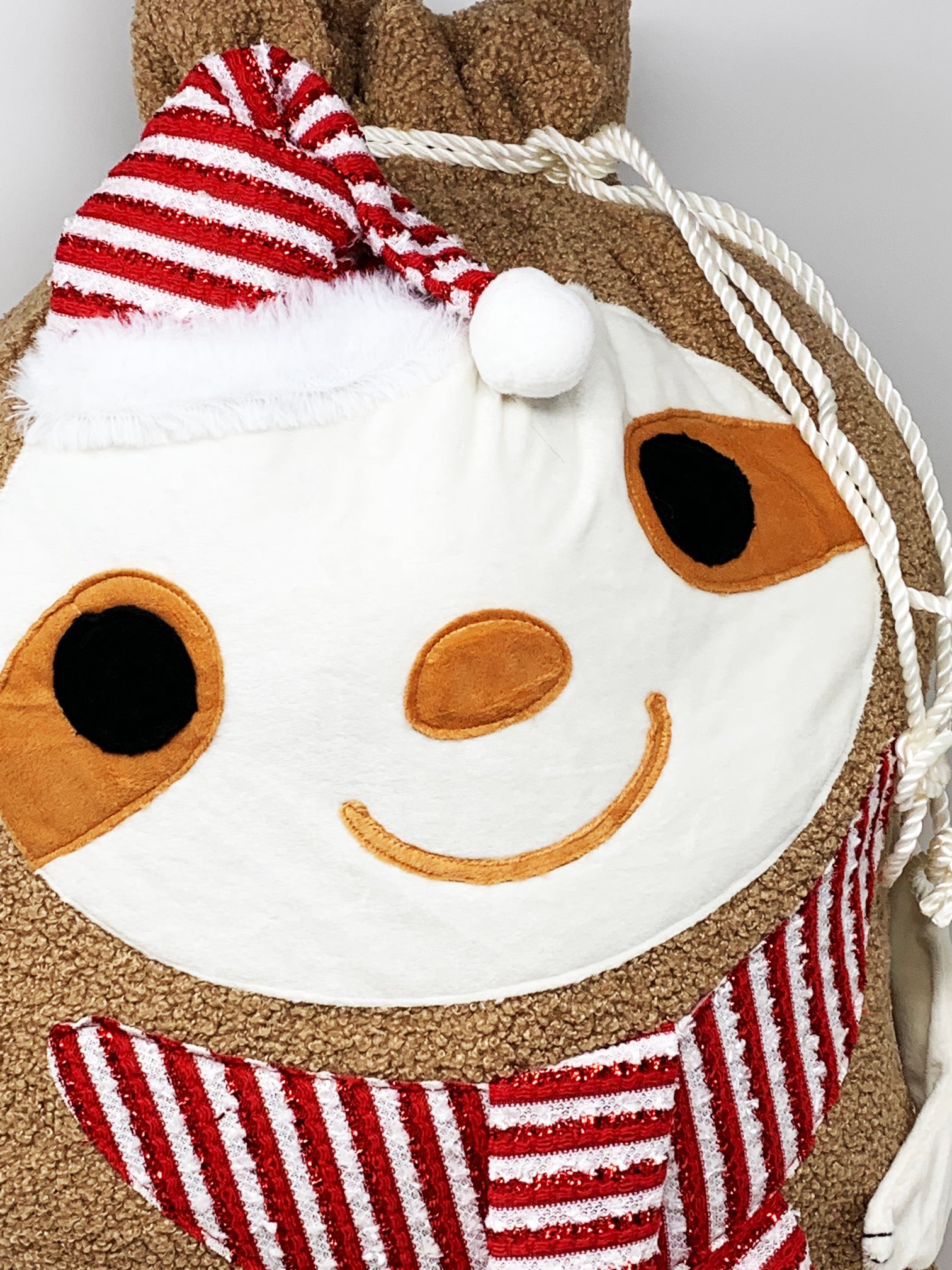Close-up of the embroidered sloth face and stitched accents on the soft fleece Christmas gift bag.