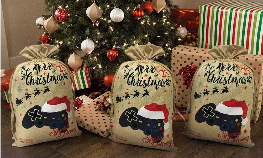 Close-up of the embroidered game controller wearing a Santa hat on the burlap canvas gamer Christmas gift bag, showing the stitching detail.